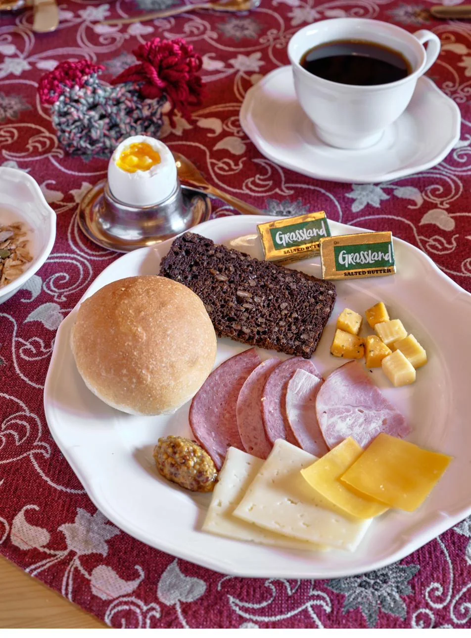 Plated Bavarian breakfast with roll, meats, cheeses, and soft-boiled egg